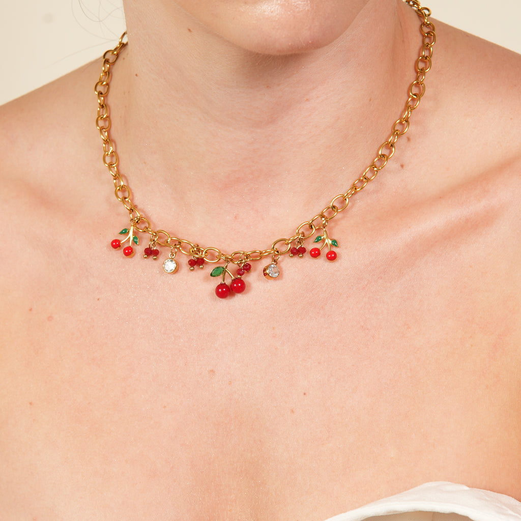 Bina zircon cherries necklace with a golden cherry pendant and pink green zircon detail, a playful luxury piece for women that adds charm and sparkle in the UAE.