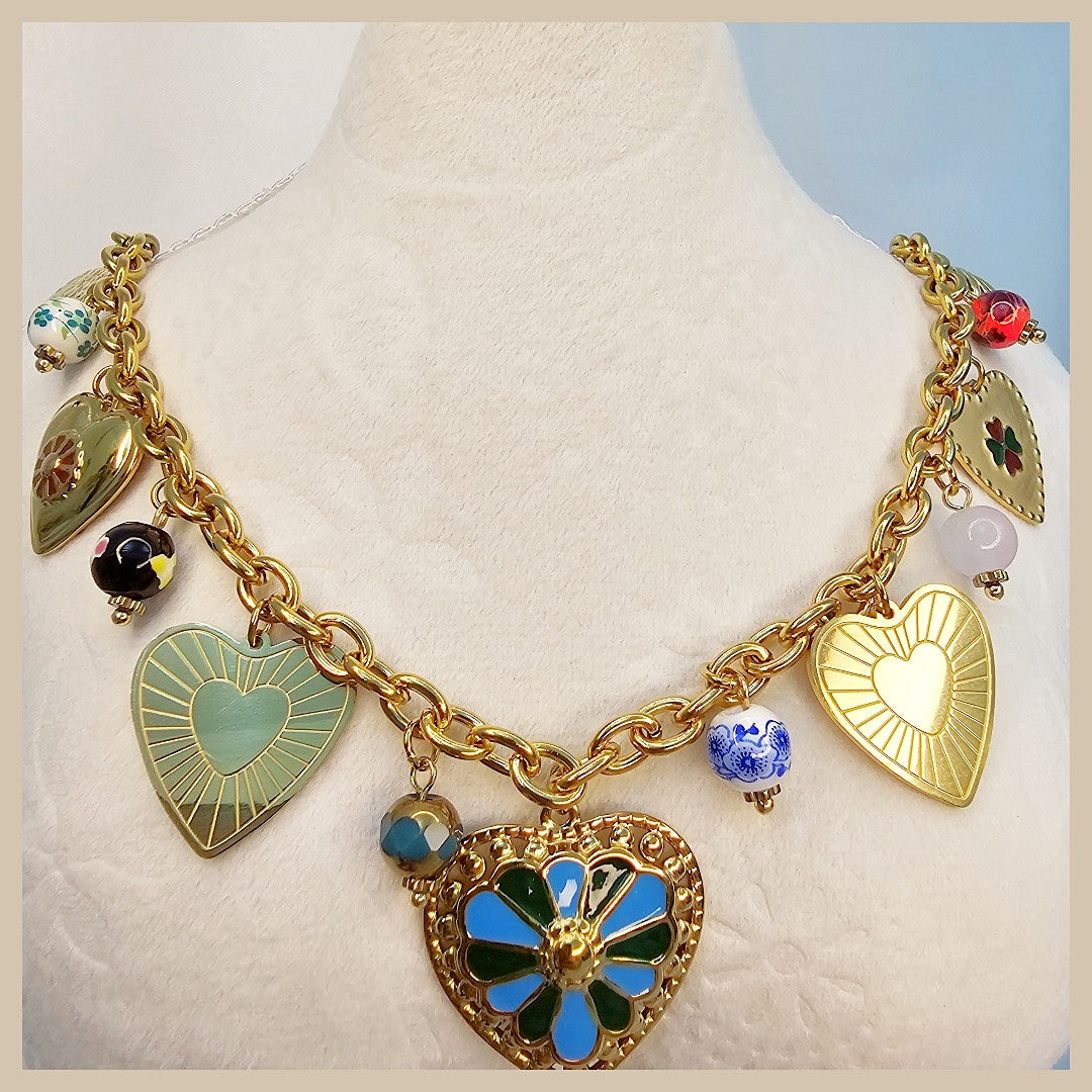 Gold necklace with heart-shaped charms on a mannequin against a light background