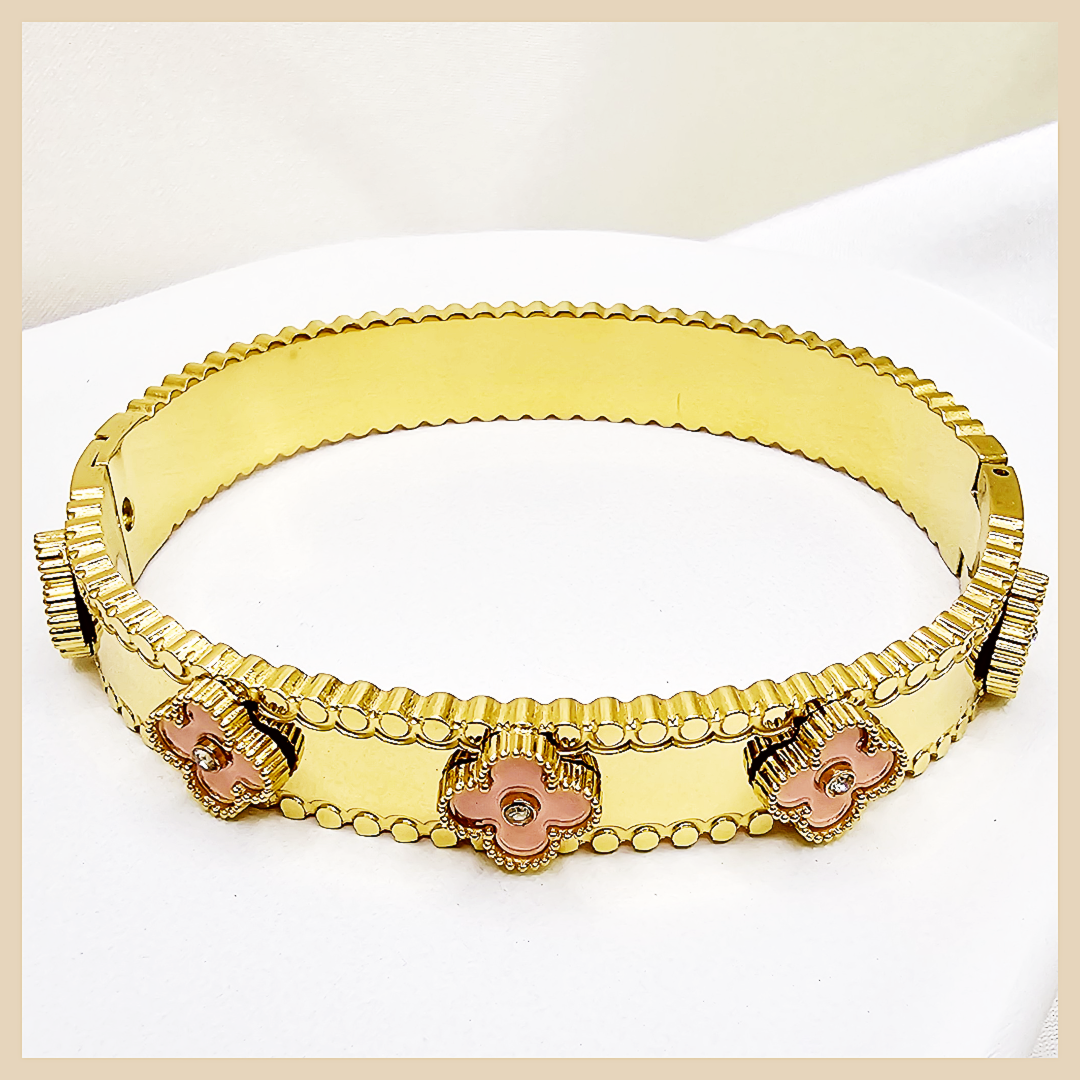 Gold bracelet with floral designs on a white background