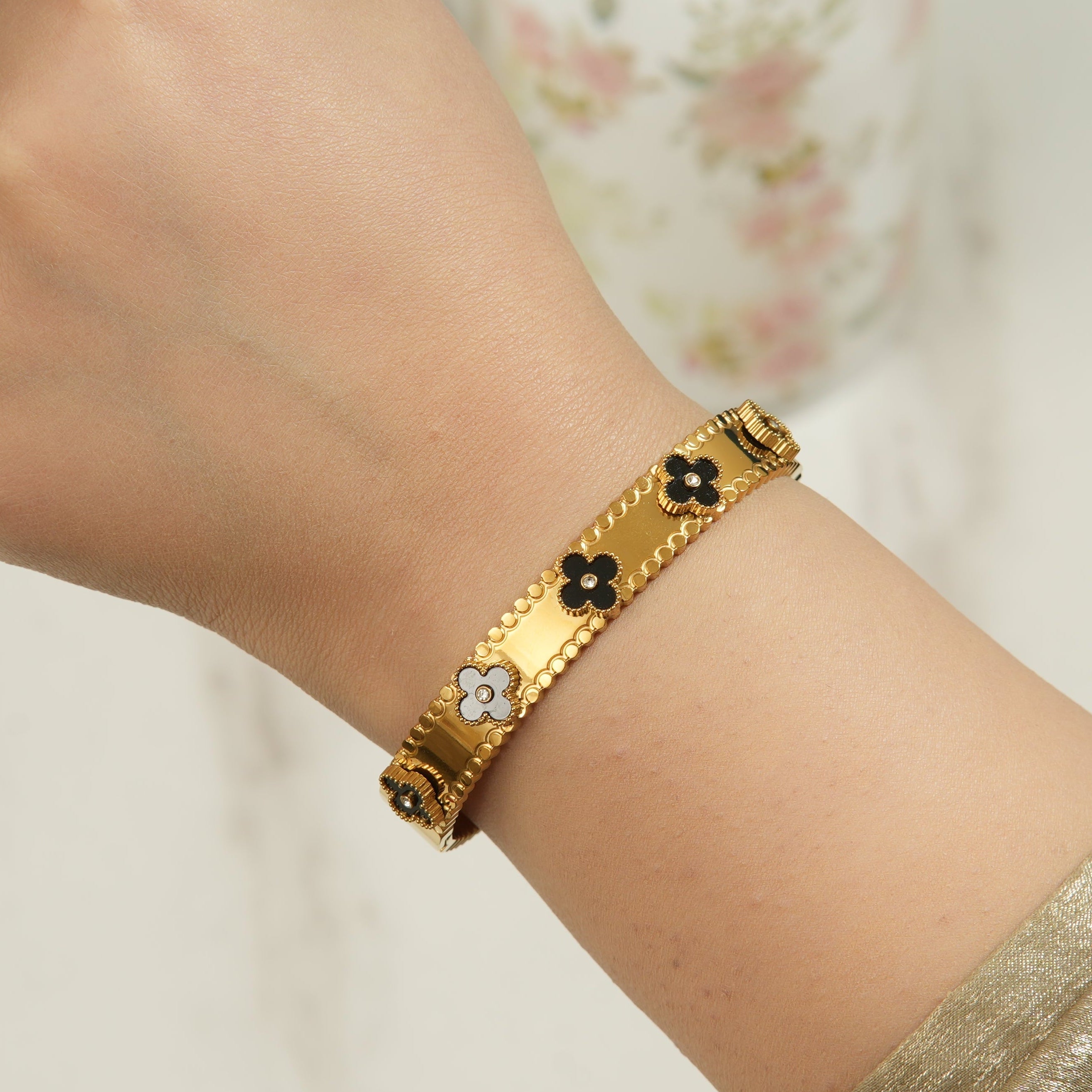Black four leaf clover zircon bangle in 18k gold plated finish, designed for confident women in the UAE who love bold luxury jewellery.
