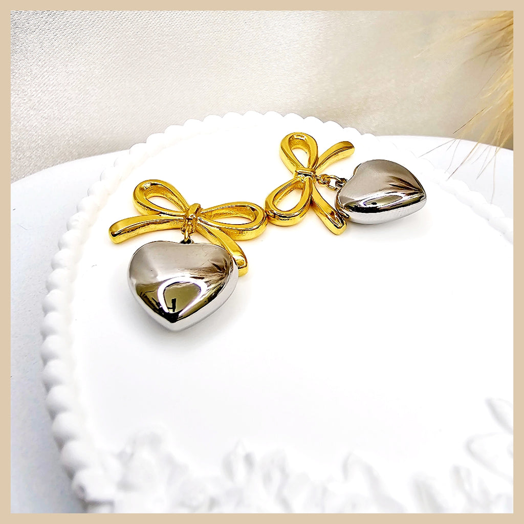 Feminine gold plated bow heart earrings styled for elegant occasions, delivering soft colour and graceful charm with a luxurious finish.
