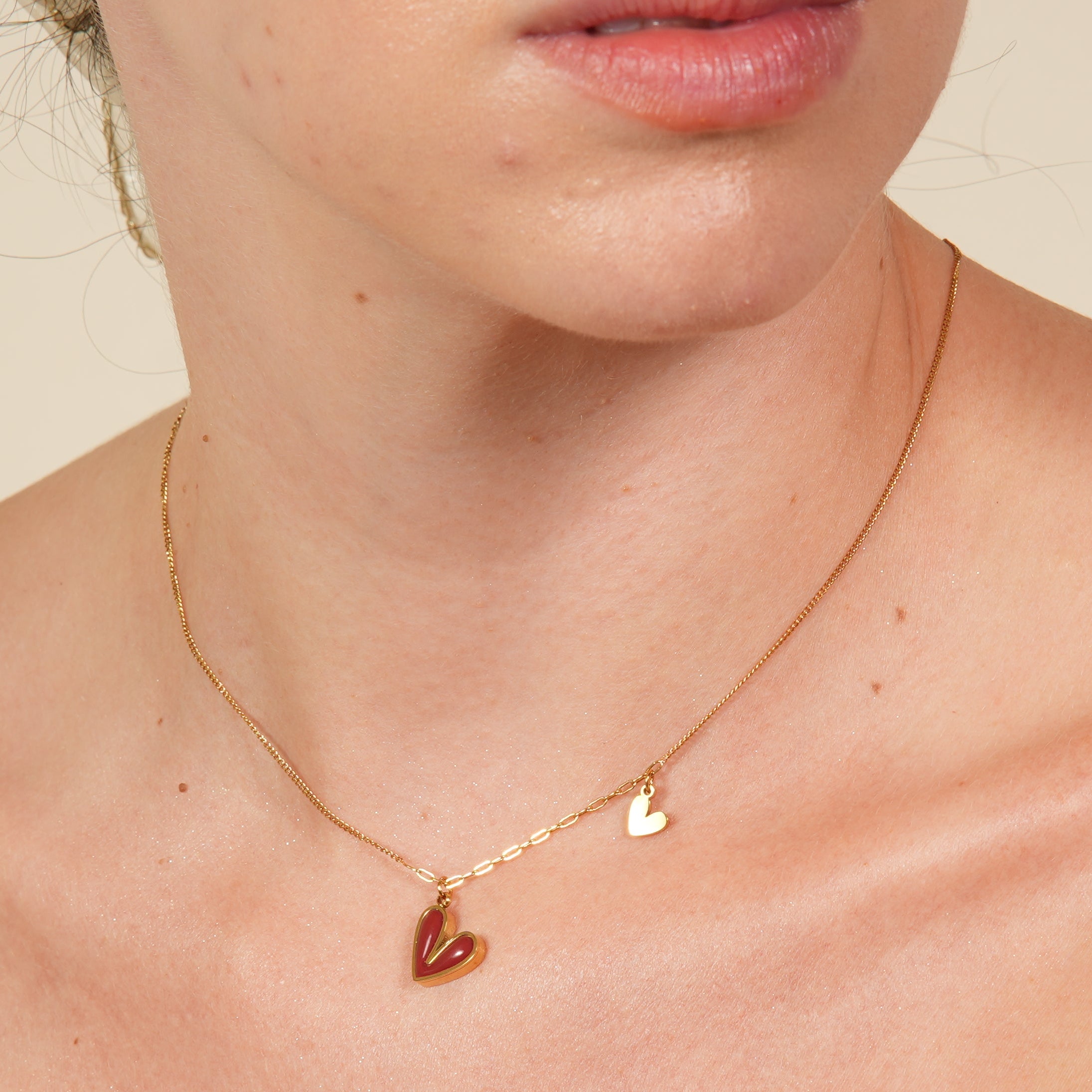 Hada 2 Hearts necklace with a pink heart-shaped pendant on a gold-plated crystal clavicle chain, designed to add romantic elegance and feminine charm for women in the UAE.